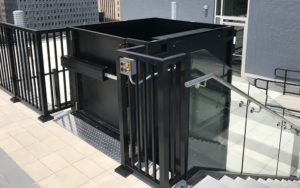 Contemporary elevator lift with safety rails on a rooftop terrace.