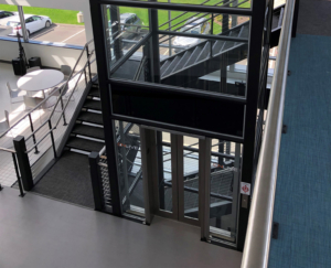 Contemporary glass elevator with sleek design and safety features.