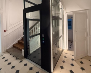 Contemporary home elevator with glass panels in elegant interior setting.