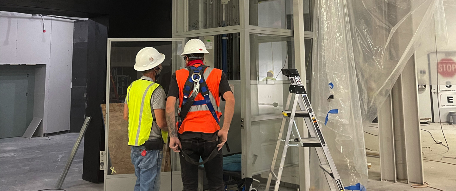 Workers-installing-lift-in-new-construction Workers Installing Lift In New Construction