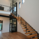 Residential elevator installed adjacent to a staircase